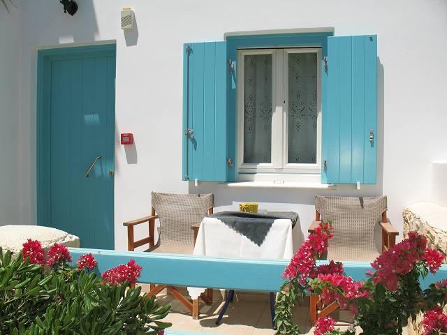 Whitewashed facade with blue shutters and bougainvillea
